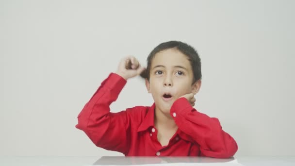 Little boy in the red long-sleeved shirt sat, combing his hair and talking all the time.studio shot white background.high quality video 4K.  - Footage, Video