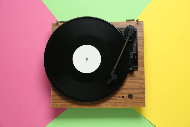Turntable with vinyl record on color background, top view - 写真・画像