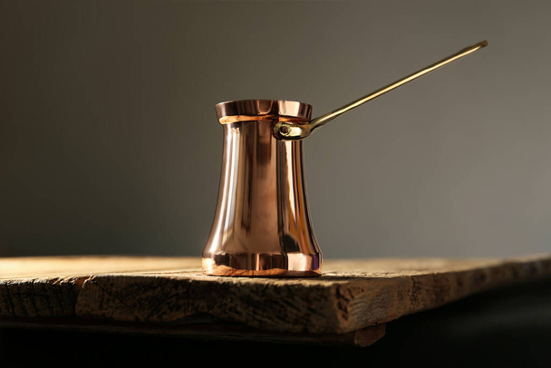 Beautiful copper turkish coffee pot on wooden table - Zdjęcie, obraz