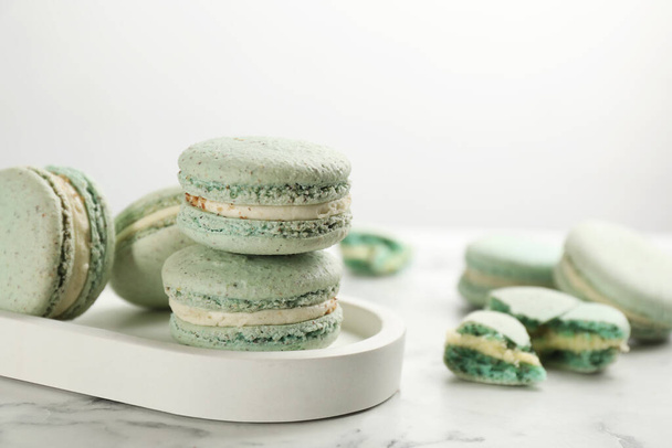 Delicious macarons on white marble table, space for text. Sweet dessert - Photo, Image