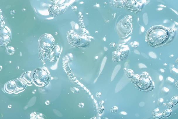 Close up macro Aloe vera gel cosmetic texture blue background with bubbles. Lemongrass gel skincare product. antibacterial liquid with aloe vera, moisturizing. Safe and environmental friendly. - 写真・画像