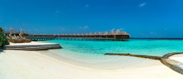 Hämmästyttävä laaja panoraama trooppinen Malediivit saari. Eksoottinen ranta tausta sininen laguuni, turkoosi vesi ja palmuja aurinkoisena päivänä. Loma, loma ja romanttinen kuherruskuukausi matkakohde. - Valokuva, kuva