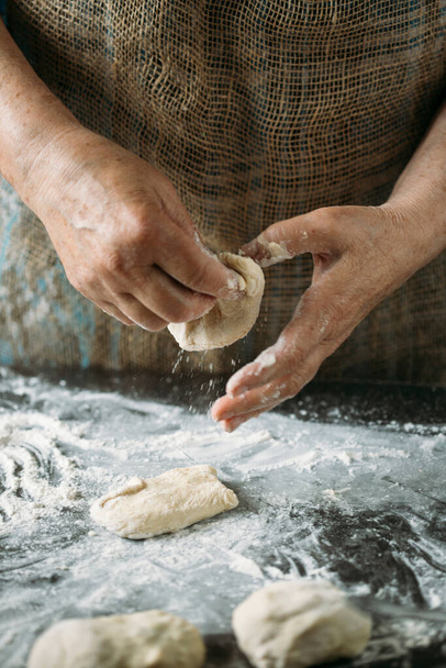 close-up view of hands making delicious pies with dough - Photo, Image