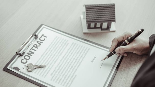 保険、販売管理者またはディーラーとの家を販売することは、モデルハウス、住宅不動産および保険の概念を持つ住宅プロジェクトを開くための承認に署名しました. - 写真・画像