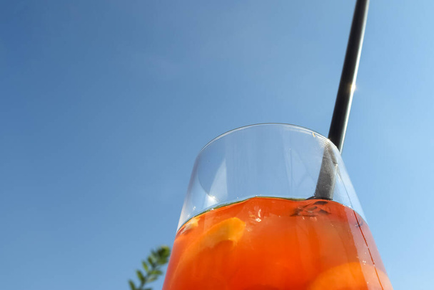 Refreshing orange summer cocktails with ice against a blue sky background.  - 写真・画像