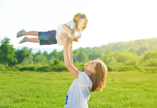 счастливая семья. Мать бросает ребенка в небо
 - Фото, изображение