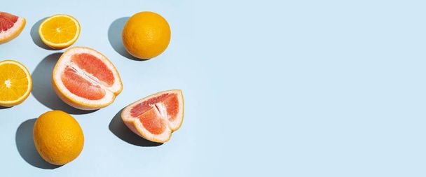 Zitrusfrüchte, Orangen, Grapefruit auf blauem Hintergrund. Draufsicht, flache Lage. Banner. - Foto, Bild