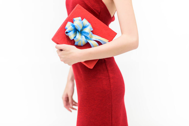 Ευτυχισμένη γυναίκα με κόκκινο φόρεμα κρατώντας κουτί δώρου Απομονωμένο σε λευκή πλάτη - Φωτογραφία, εικόνα