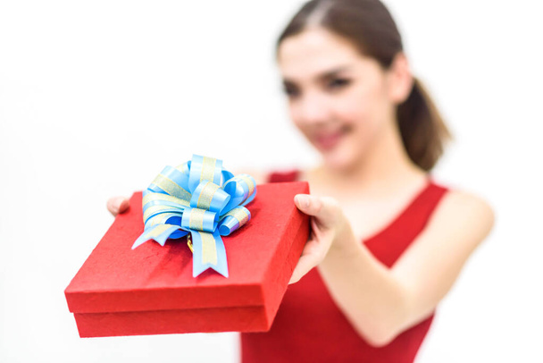 mujer feliz en vestido rojo sosteniendo caja de regalo aislado en la espalda blanca - Foto, Imagen