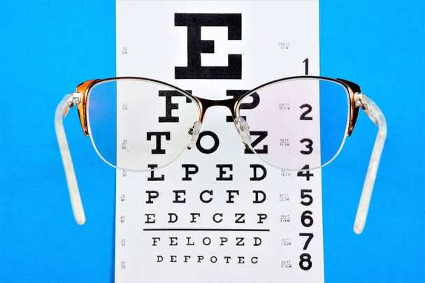 Έλεγχος όρασης. πίνακας οφθαλμικών χαρτών για διαγνωστικά οπτικής οξύτητας, γυαλιά με διόπτρες για διόρθωση της βελτίωσης της όρασης. - Φωτογραφία, εικόνα