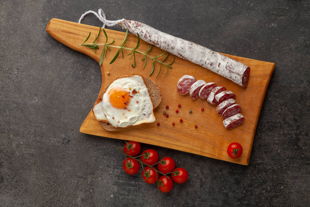 Sausage fuet smoked dry-cured salami meat on the table meal snack outdoor top view food background rustic image. - Фото, изображение