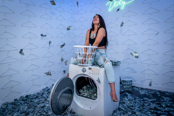 Um modelo asiático bonito joga em uma sala colorida com uma enorme quantidade de dinheiro ilegal - Foto, Imagem