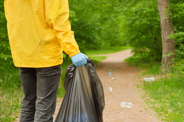 Wolontariusze zbierają śmieci w lesie. Wolontariuszka sprząta śmieci w parku. Plastik zanieczyszczający środowisko. Środowisko przyjazne dla środowiska. Chroń środowisko naturalne. Koncepcja ochrony środowiska - Zdjęcie, obraz
