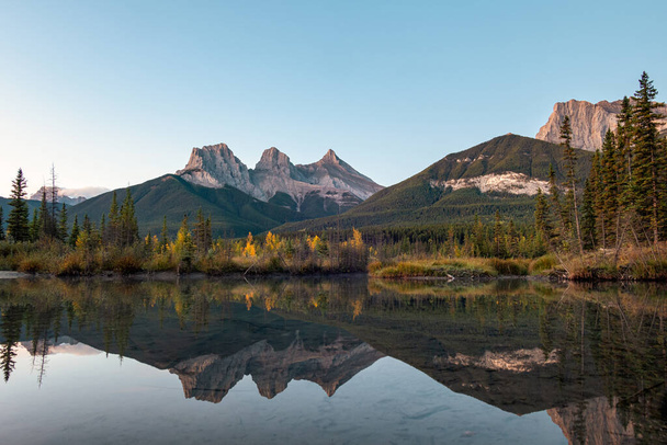 Trois sœurs montagnes de montagnes rocheuses réfléchissent sur la rivière bow le matin à Canmore, parc national Banff, Canada - Photo, image