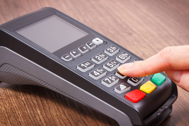 Payment terminal and finger entering PIN code. Credit card reader using for cashless paying. Finance concept - Photo, Image