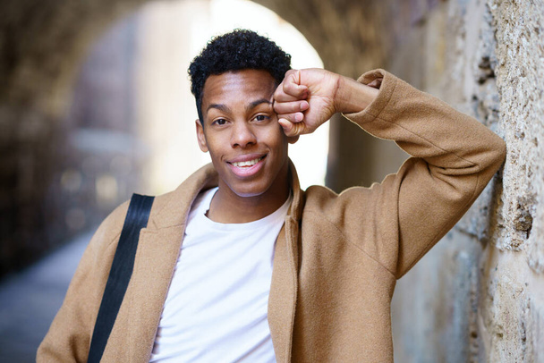 Young black man looking at camera outdoors. - Fotó, kép