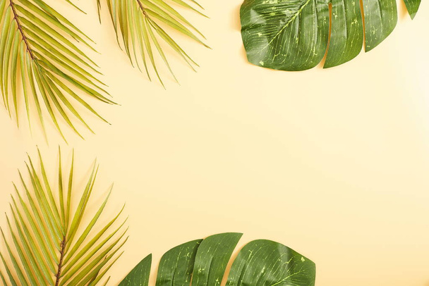 Deitado plano, vista superior, espaço de cópia. Folhas de palma tropicais no fundo amarelo. - Foto, Imagem