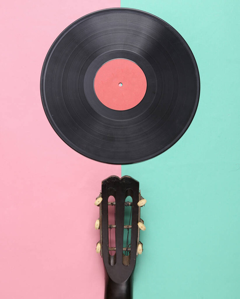 Акустическая гитара, виниловая пластинка на розовом синем фоне. Музыкальная концепция. Минимализм. Вид сверху. Плоский лежал - Фото, изображение