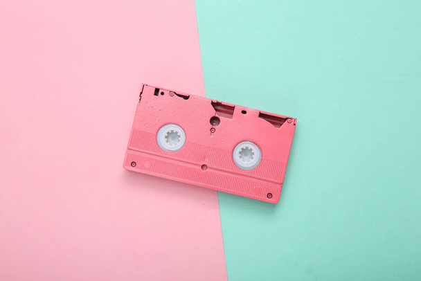 Pink video cassette on pink blue pastel background. Minimalism. Flat lay. Top view. - Photo, Image