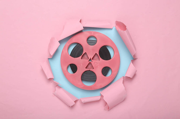 Creative music layout. Pink audio reel through torn hole of pink blue paper. Pastel color trend. Fresh idea. Minimalism. Concept art. Flat lay. Top view. - Photo, Image
