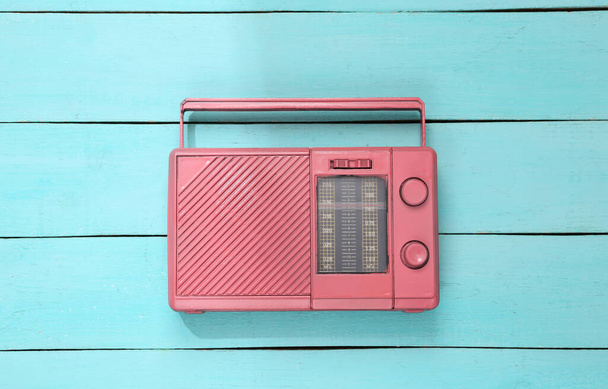 Pink radio receiver on blue wooden background. Creative music layout. Top view. Flat lay - Photo, Image