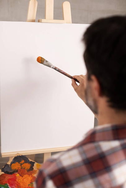 Male artist working on painting. Man artist painter in creative studio as art concept - Fotoğraf, Görsel