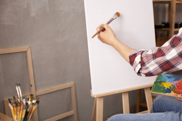 Male artist working on painting. Man artist painter in creative studio as art concept - Φωτογραφία, εικόνα