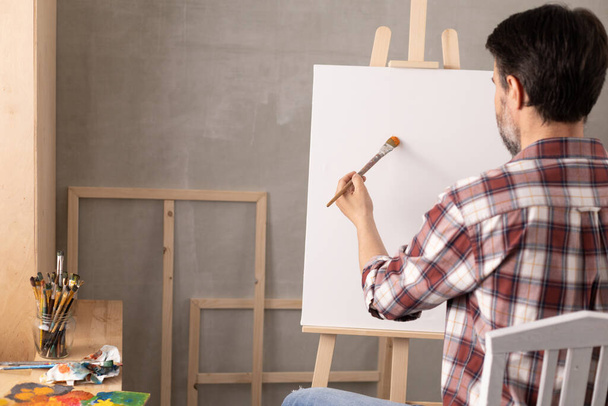 Male artist working on painting. Man artist painter in creative studio as art concept - Foto, imagen