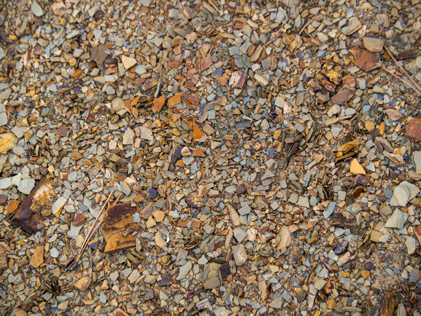 Textura tierra de grava marrón. Antecedentes de tierras rocosas. Varias piedras de color marrón y rojo de cerca. - Foto, Imagen