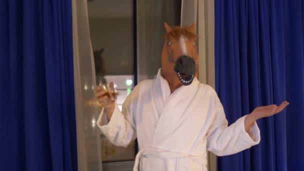 Homem com uma máscara de cavalo relaxando e bebendo uísque depois do trabalho em 4k - Filmagem, Vídeo