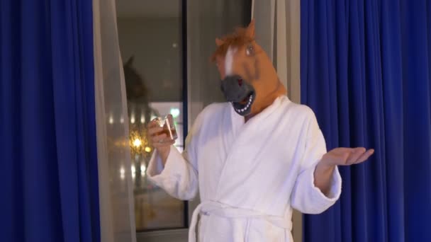 Man in a horse mask relaxing and drinking whiskey after work in 4k - Footage, Video