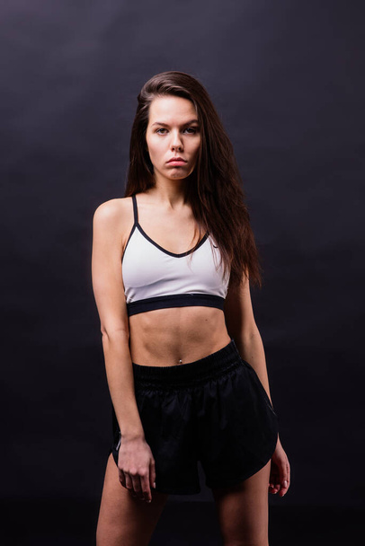 Posa fitness donna seducente isolato su uno sfondo grigio - Foto, immagini