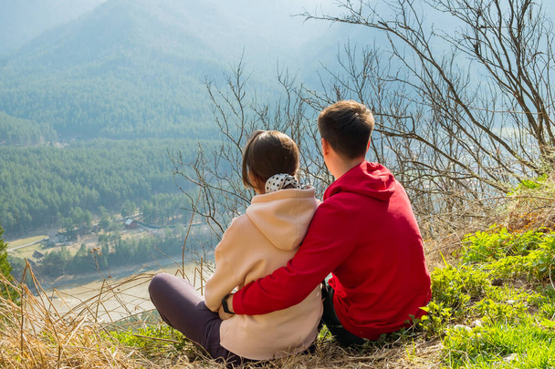 Young traveler couple resting and taking selfie in the mountains. Man and woman hiking with backpacks on a beautiful rocky trail. Family local travel and adventure concept - Valokuva, kuva