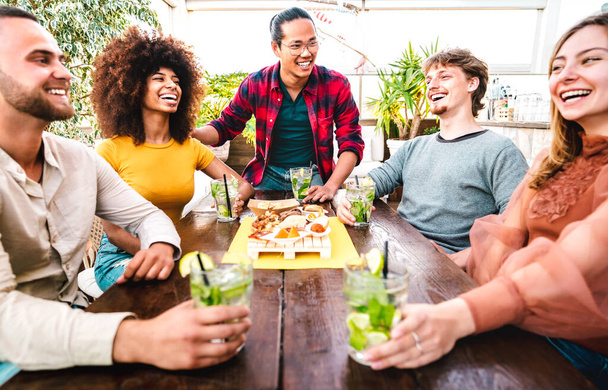 Weite Sicht auf Menschen, die Mojito im Mode-Cocktail-Pub-Restaurant trinken - Party-Time-Konzept mit jungen Freunden, die Spaß bei ausgefallenen Drinks zur Happy Hour an der Bar haben - Foto, Bild