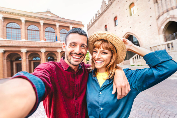 Young boyfriend and girlfriend in love having fun taking selfie at old town tour - Wanderlust life style travel concept with tourist couple on city sightseeing vacation - Photo, Image