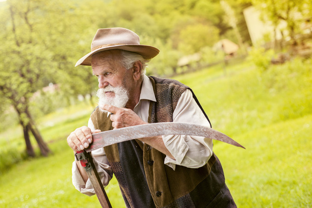 Farmer preparing his scythe - Foto, Imagen