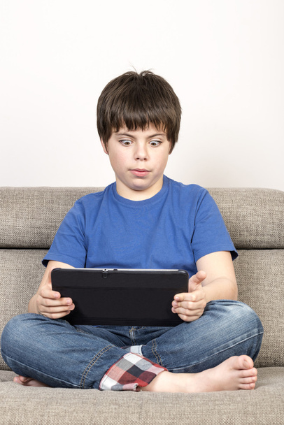Sorpreso giovane ragazzo e un tablet digitale
 - Foto, immagini