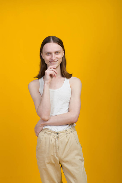 Androgynous beautiful young man. Model tests in yellow background - Fotoğraf, Görsel