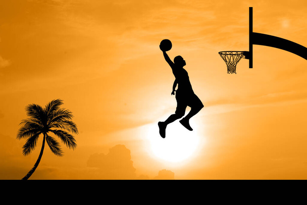 Basketbalspelers springen dunk silhouetten op een prachtige outdoor basketbalveld in de avond. - Foto, afbeelding
