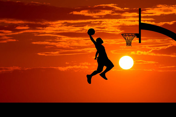Koszykarze skaczących dunk sylwetki na pięknym boisku do koszykówki wieczorem. - Zdjęcie, obraz