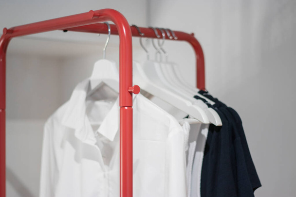 Clothes Hanging On A Rack. Shopping and space organization, minimalist. - Zdjęcie, obraz
