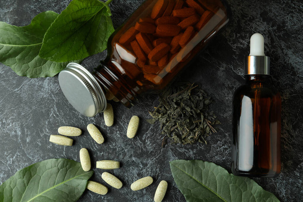 Έννοια των βοτάνων χάπια ιατρικής σε μαύρο τραπέζι καπνιστής, top view - Φωτογραφία, εικόνα