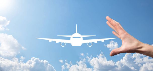 青い背景に男性の手を保持飛行機のアイコン。旅行計画、交通機関、ホテル、フライト、パスポートに関する旅行アイコンフライトチケット予約コンセプト - 写真・画像