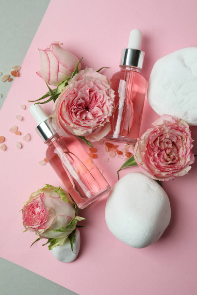 Concetto di cura della pelle con olio essenziale di rosa su sfondo bicolore - Foto, immagini