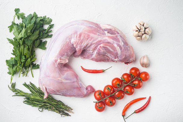 Fresh raw rabbit with olive oil, rosemary, peppers set, on white stone  background, top view flat lay - Foto, Imagen