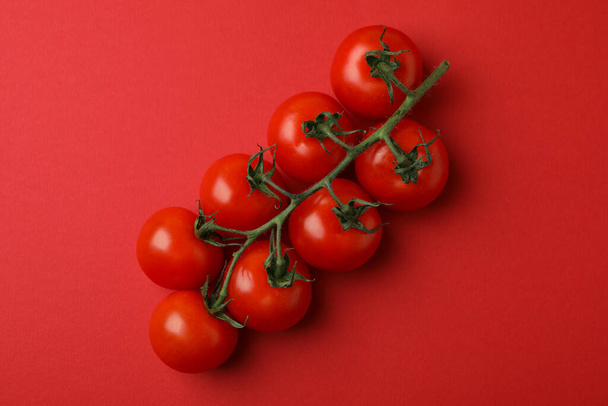 Fresh cherry tomato branch on red background - Photo, Image