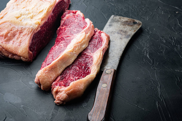 Top sirloin rundvlees steaks gesneden, op zwarte achtergrond, met kopieerruimte voor tekst - Foto, afbeelding