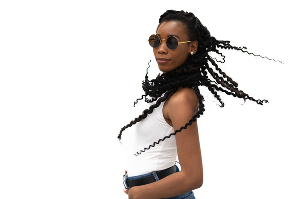 Elegante en mooie jonge Afrikaanse Amerikaanse vrouw met typische kapsel op een lichte achtergrond: Selectieve focus  - Foto, afbeelding