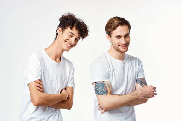 Two cheerful friends in white t-shirts stand side by side cropped view - Фото, изображение
