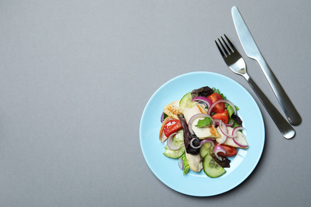 Koncept chutné jíst se salátem s grilovaným kuřecím masem na šedém pozadí - Fotografie, Obrázek